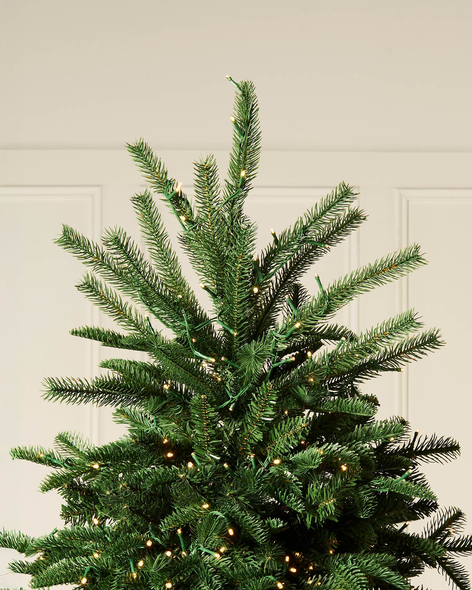 Top section of a 7.5ft pre-lit Noble Fir Christmas tree with tiered branches.