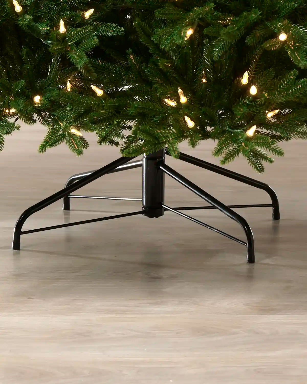 Black metal stand supporting the 7.5 ft pre-lit Heritage Spruce Christmas tree.