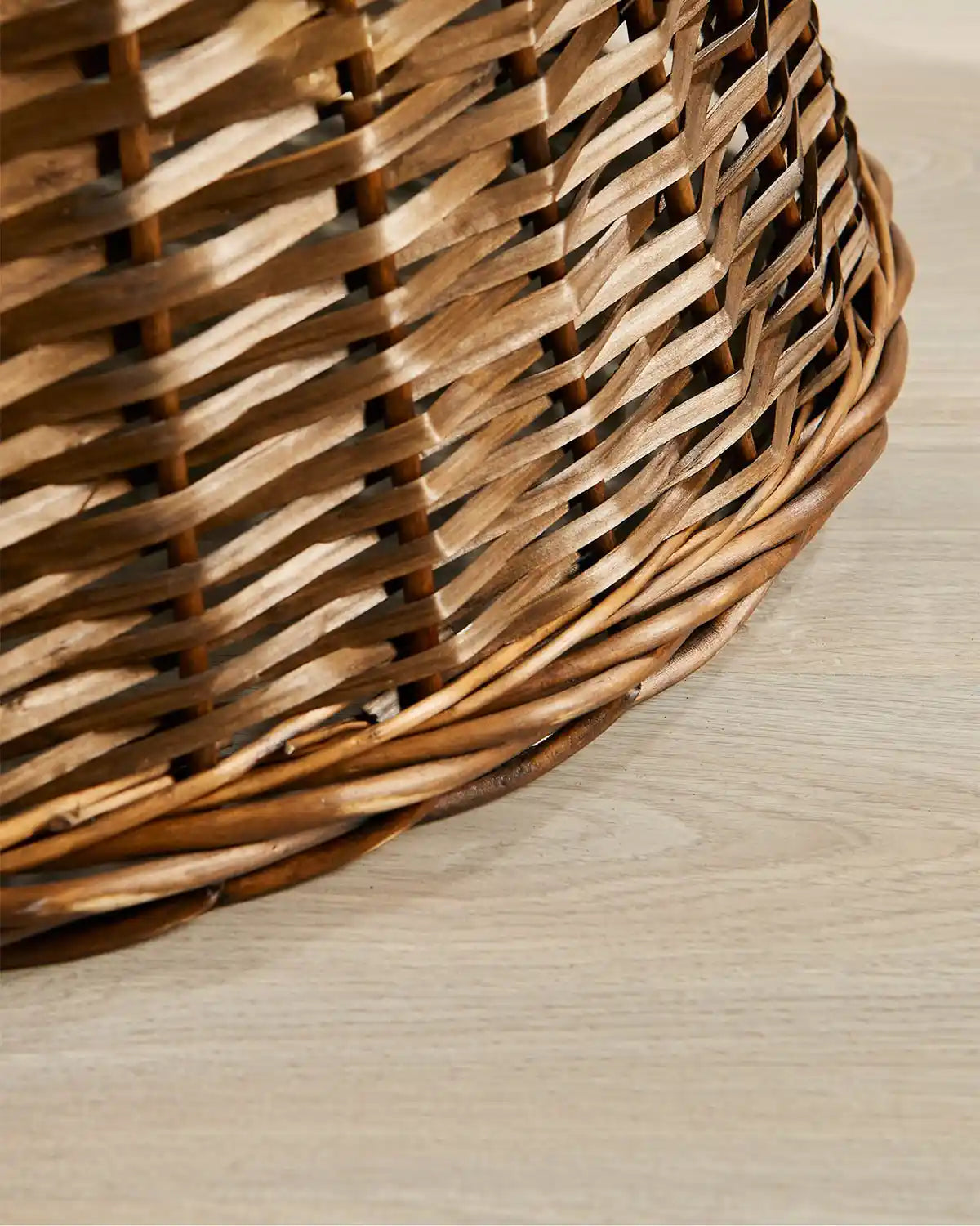 Detail view of the 70cm brown wicker tree collar with a natural woven rattan pattern and rounded lower edge.