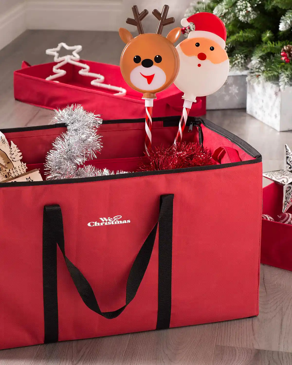 Red bauble storage box filled with Christmas decorations indoors