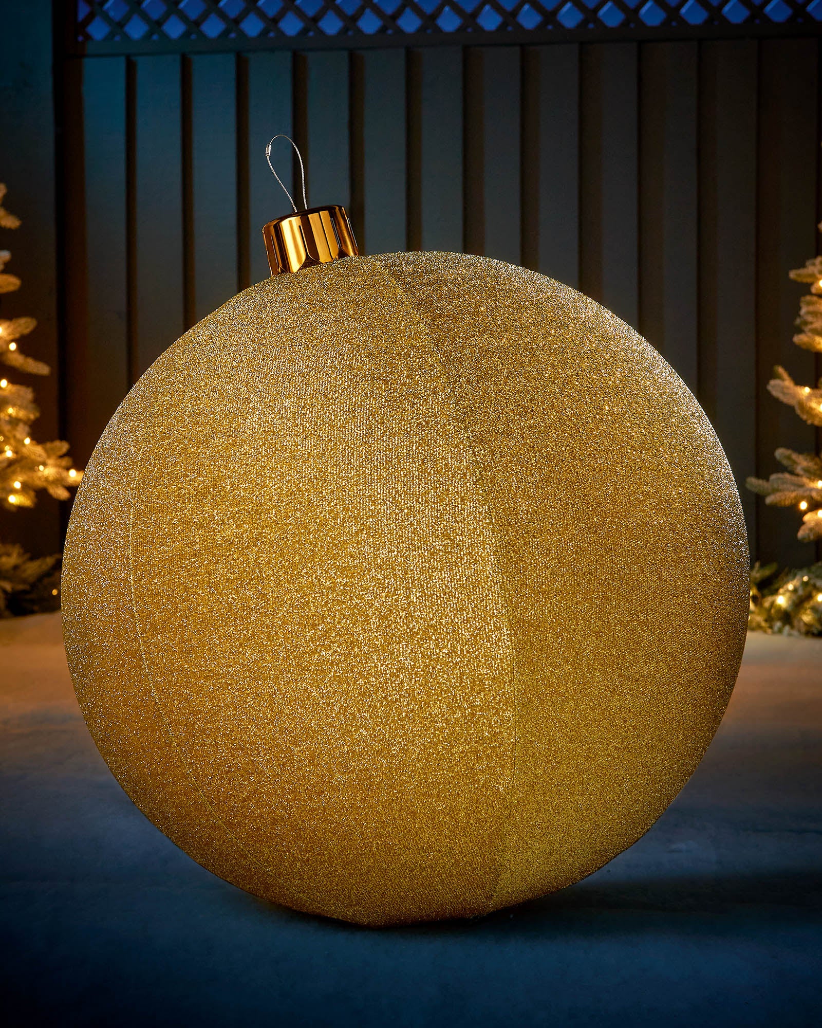 Large gold 76cm inflatable tinsel Christmas bauble with a gold cap in an outdoor festive display.