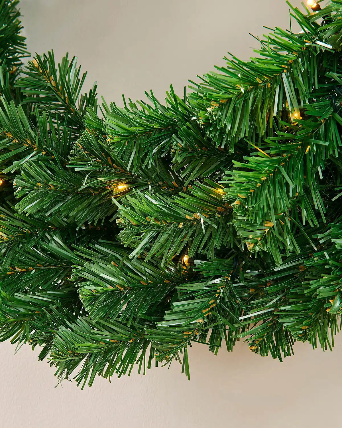Branch detail showing the dense green foliage on the pre-lit Christmas wreath
