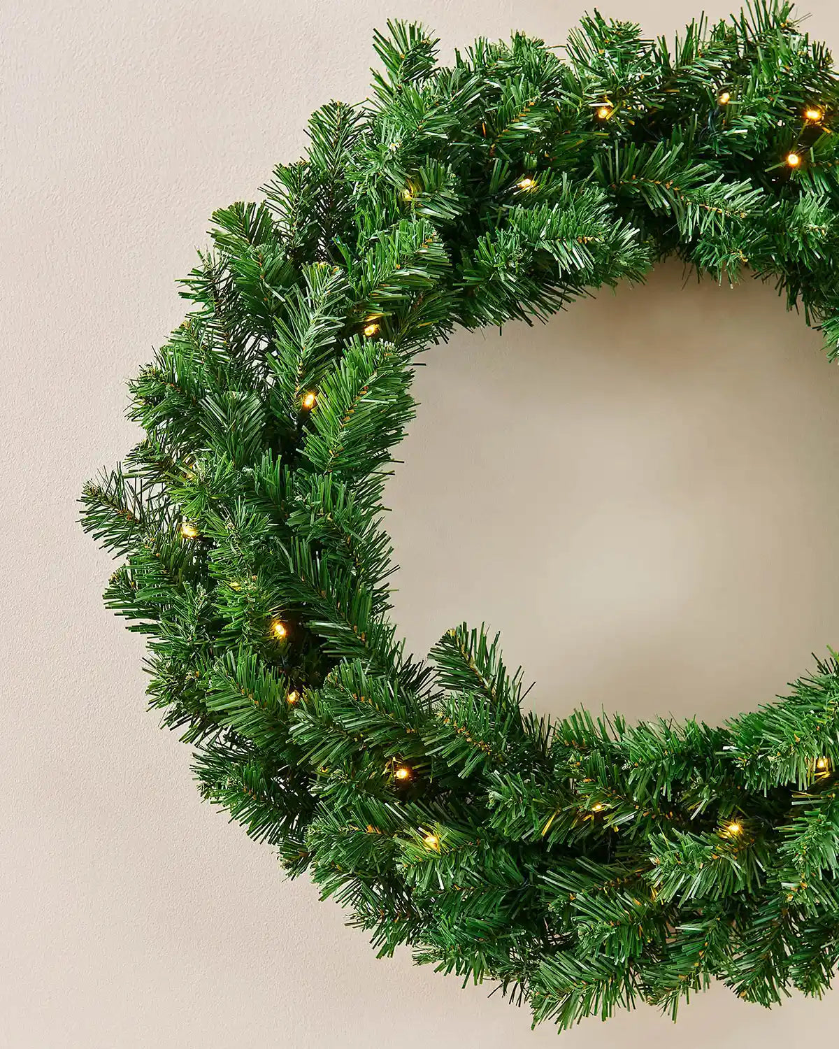 Detail of the green foliage and warm white lights on the extra thick Christmas wreath