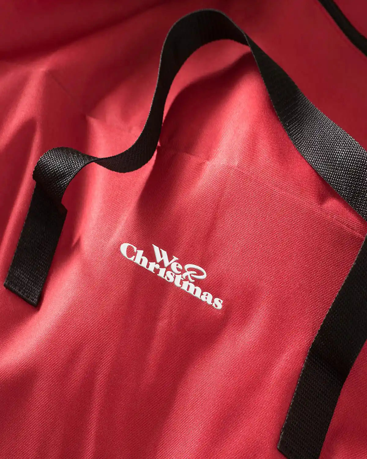 Close-up of the red Christmas tree storage bag with black carry handle and logo