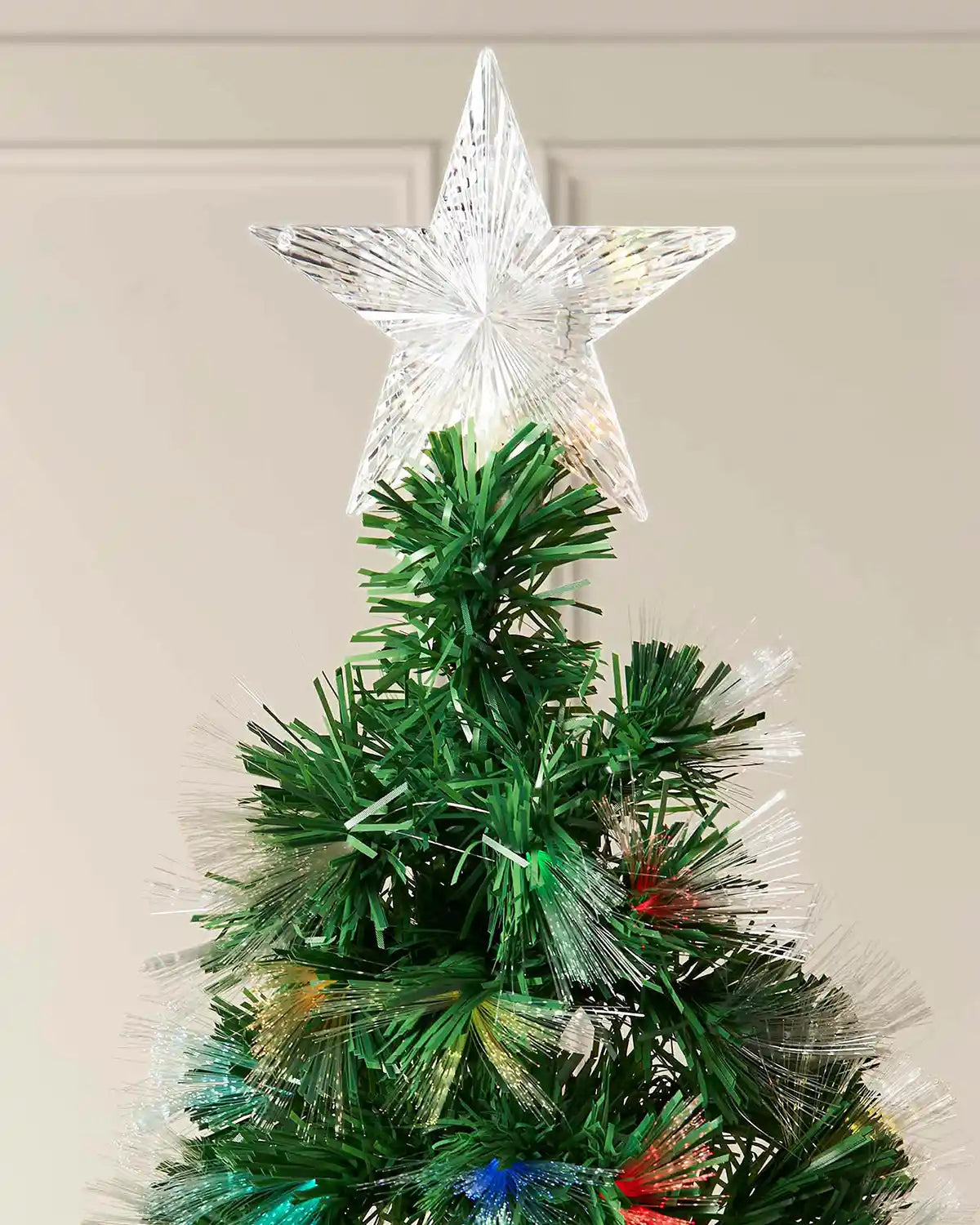 Star tree topper detail on 7ft fibre optic Christmas tree with green branches and multicolour lights