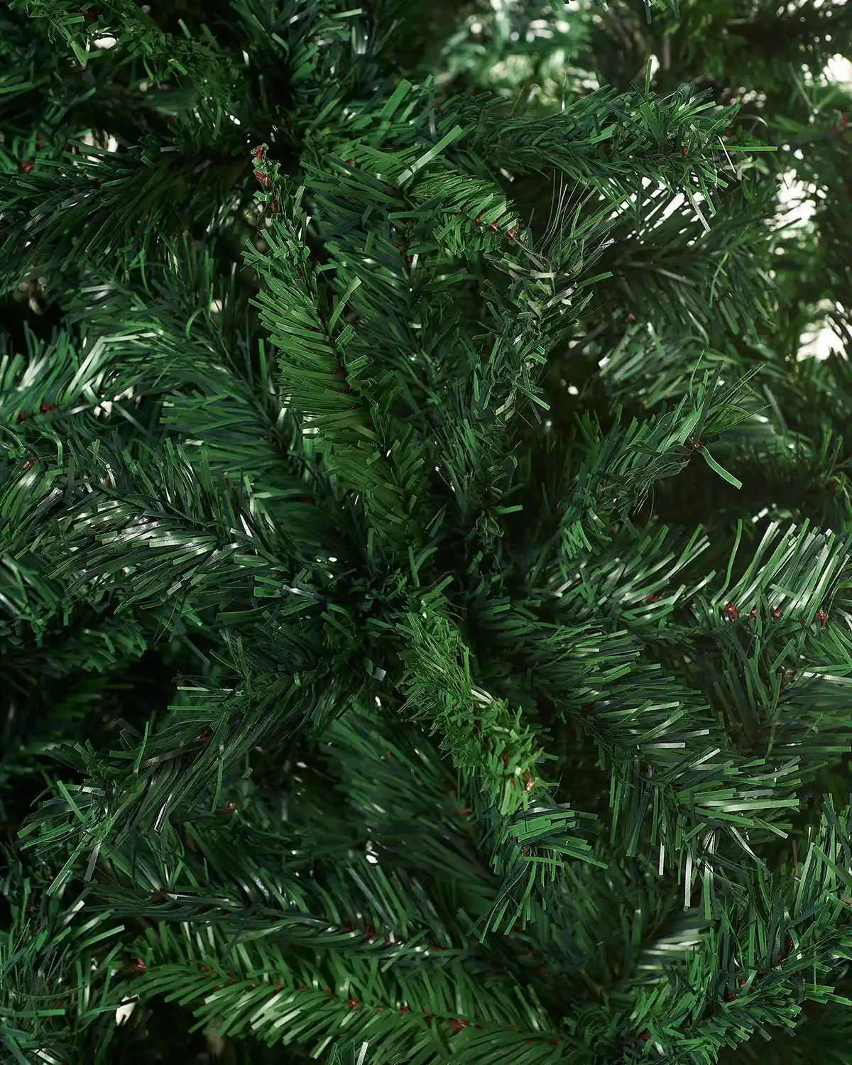 Detailed close-up of PVC green pine needles on an artificial Christmas tree