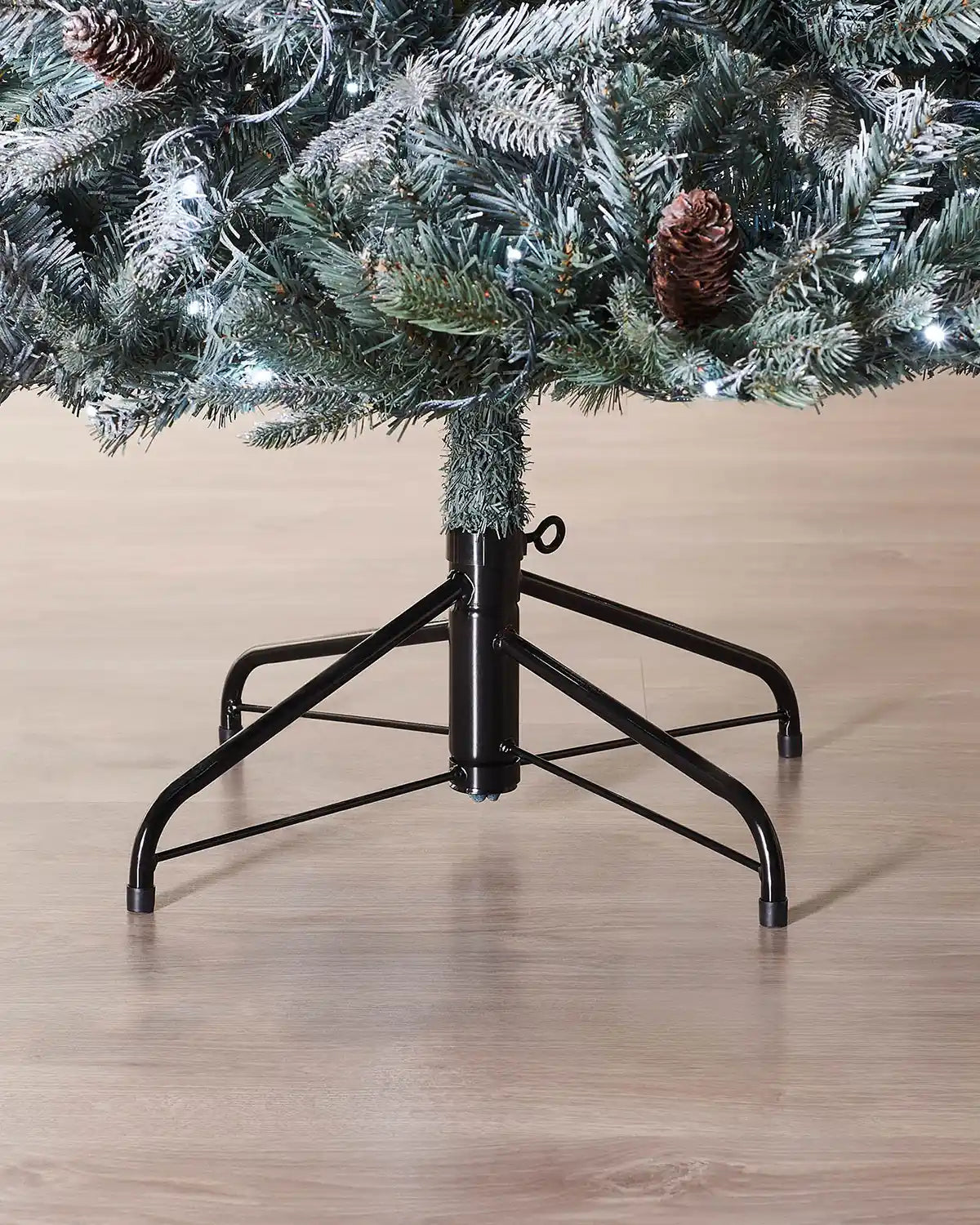 Base of the 7 ft Edwardian Spruce Christmas tree with frosted branches and metal tree stand