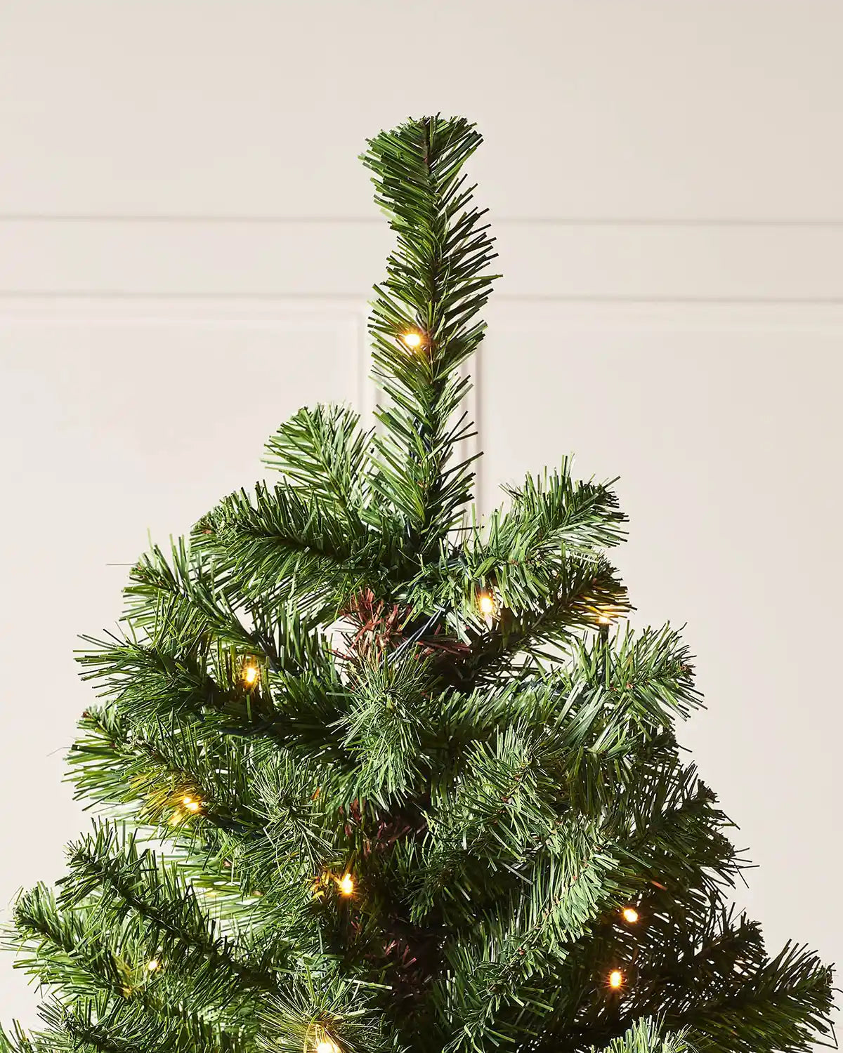 Top section of a 7 ft emerald spruce Christmas tree with warm white LED lights