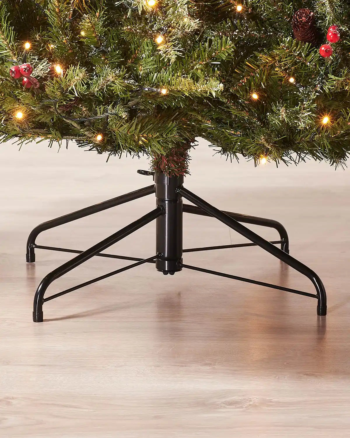 Close-up of the metal tree stand beneath a 7ft pre-lit frosted decorated Christmas tree