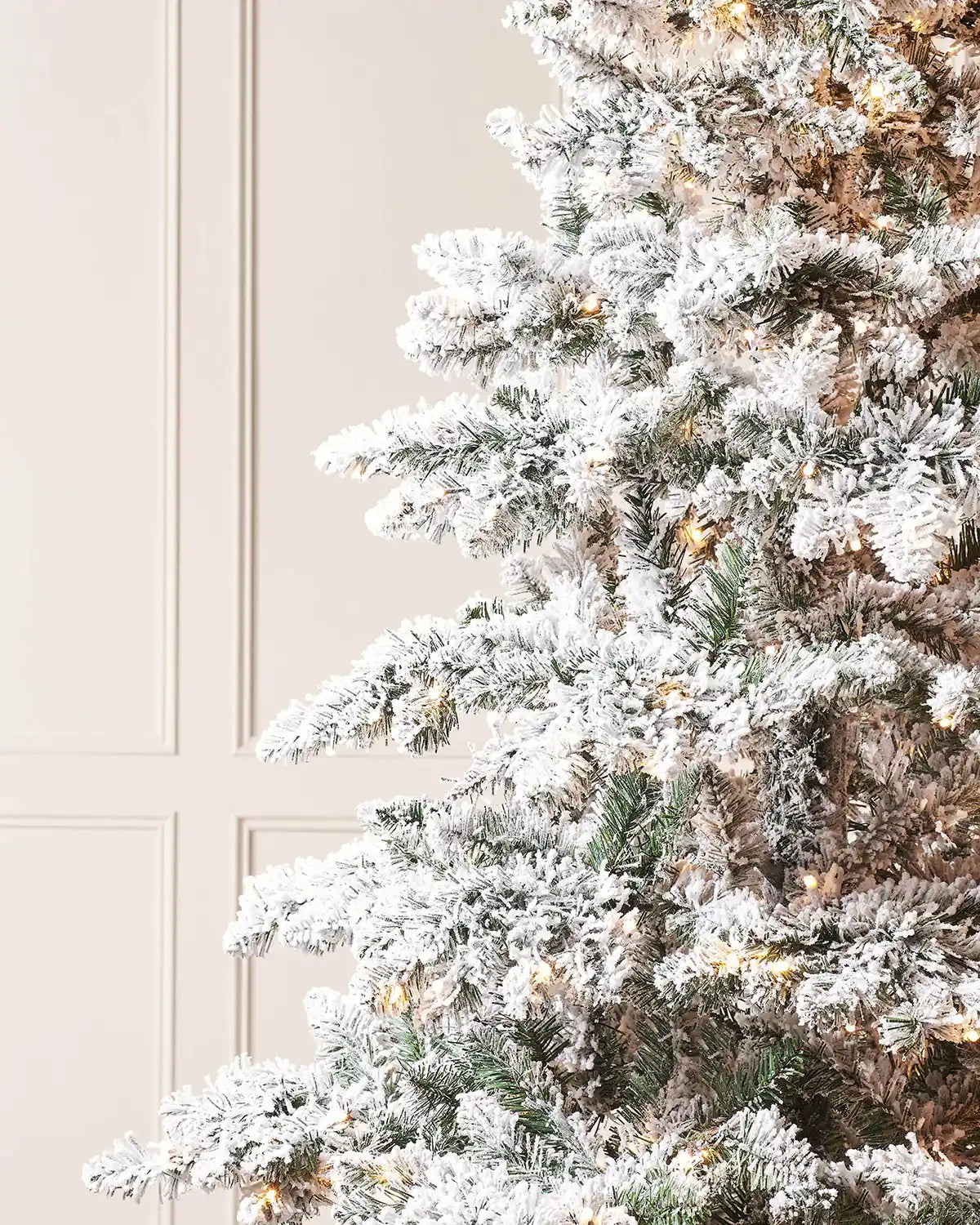 Close-up of snow flocked branches on pre-lit Alpine Christmas tree