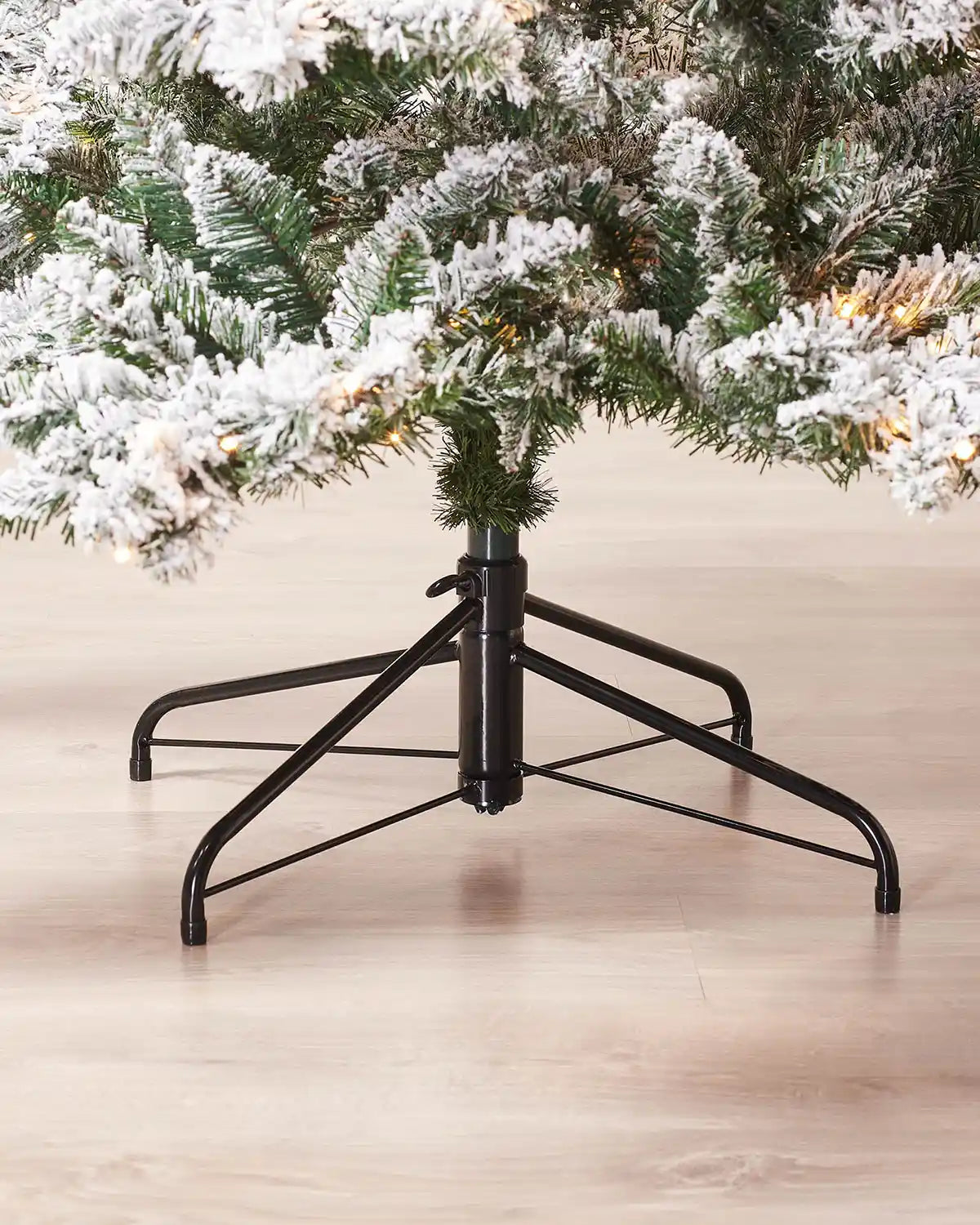 Metal stand detail of 7 ft pre-lit snow flocked Alpine Christmas tree