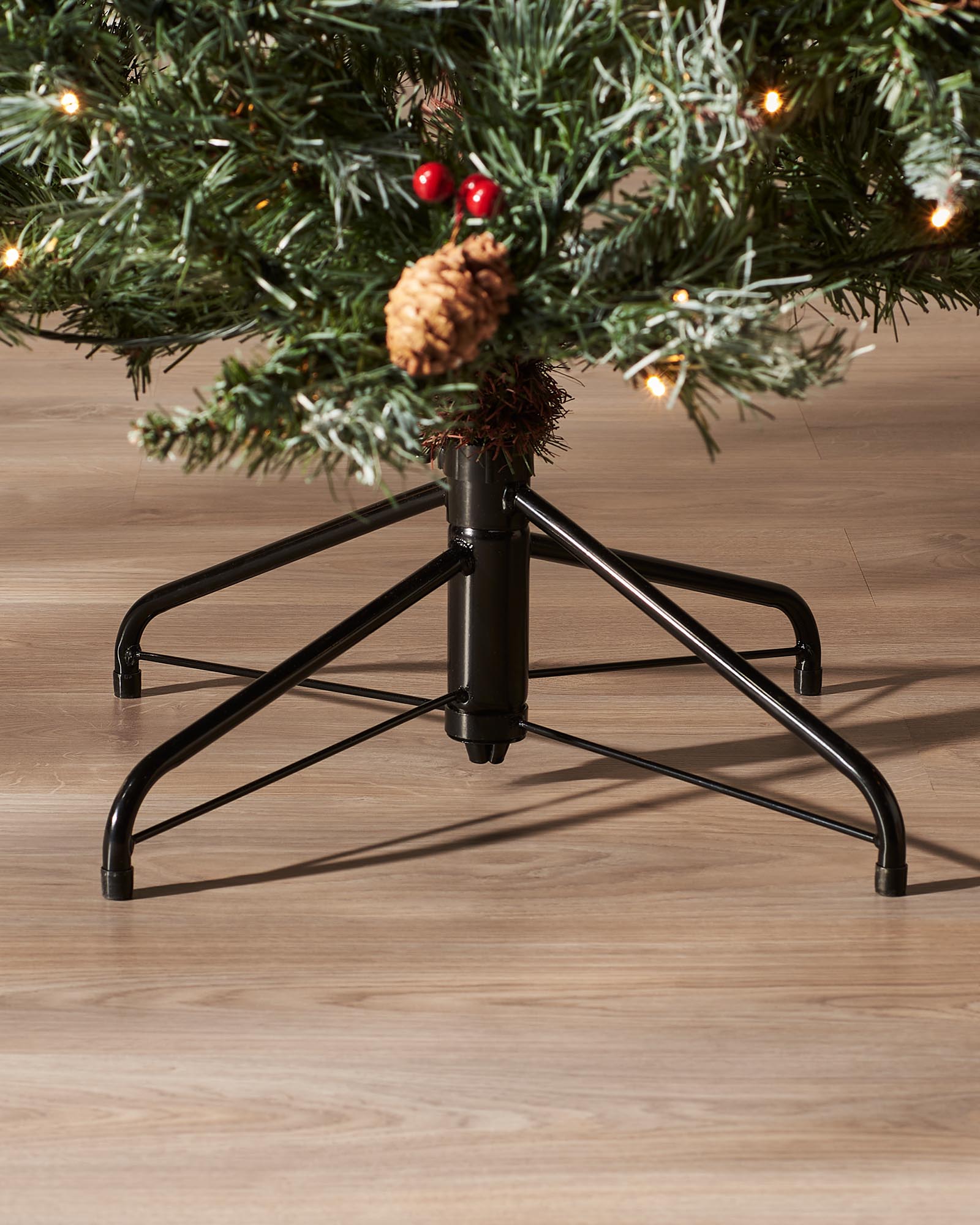 Close-up of the metal tree stand beneath a 7 ft pre-lit Scandinavian spruce Christmas tree