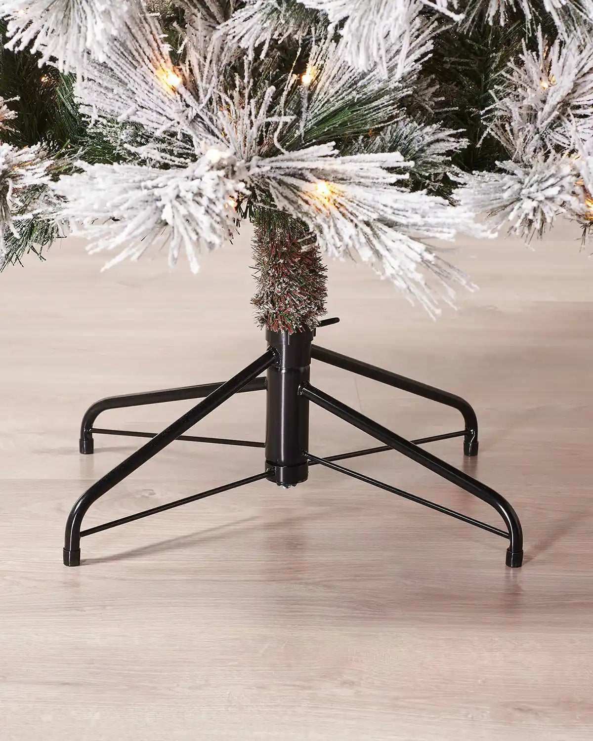 Close-up of the foldable metal stand on the 7 ft snow flocked pine needle tree