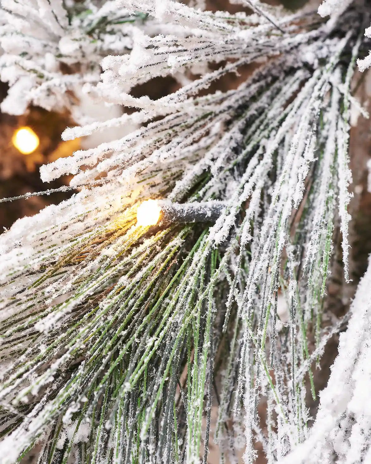 Close-up of warm white LED lights on the 7 ft snow flocked pine needle tree