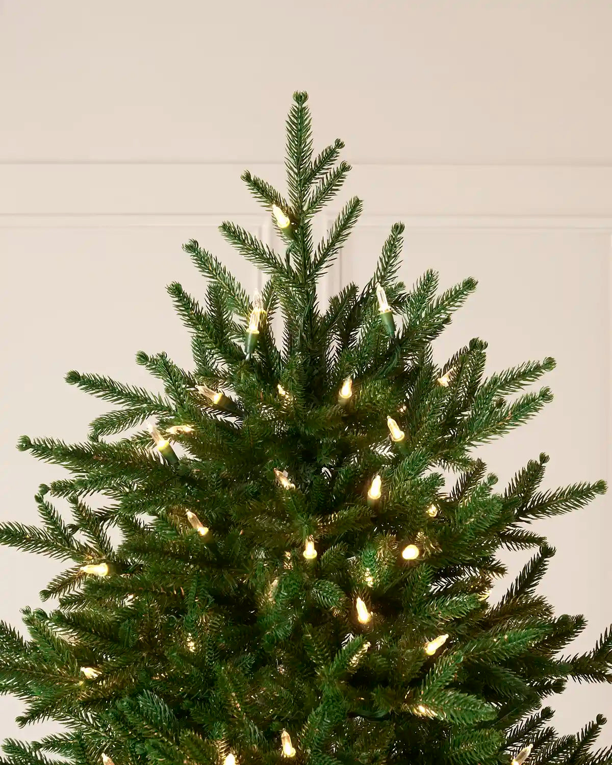 Top section of the 8.5 ft Heritage Spruce Christmas tree with warm white lights.