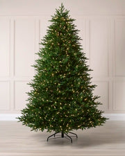 Full 8.5 ft pre-lit Heritage Spruce artificial Christmas tree with 1,050 warm white LED lights.