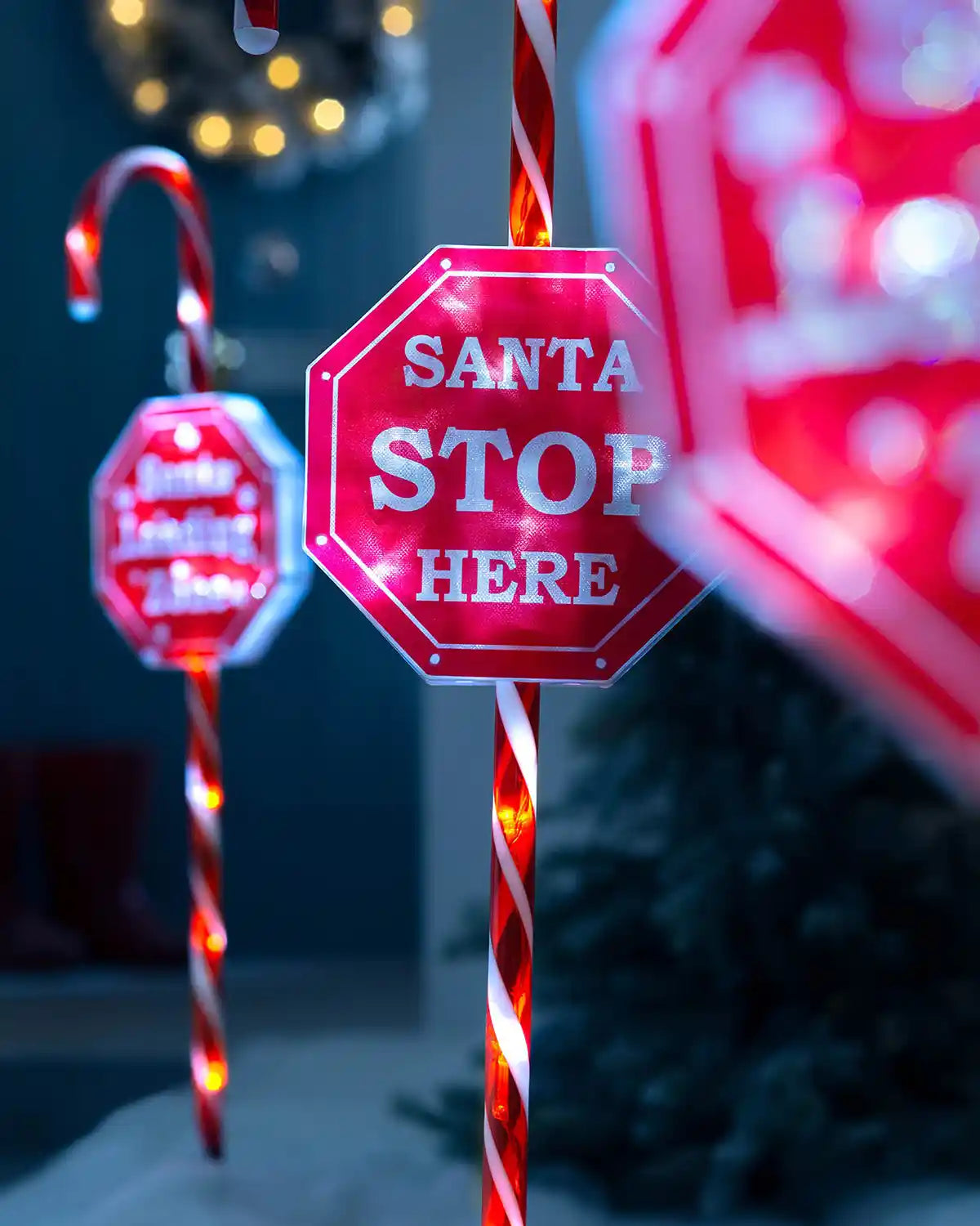 Close-up of illuminated Santa Stop Here candy cane pathway stake light