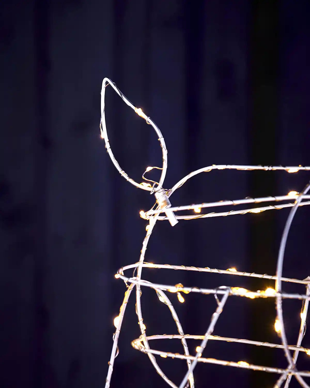 Close-up of illuminated reindeer tail detail on wire frame Christmas decoration