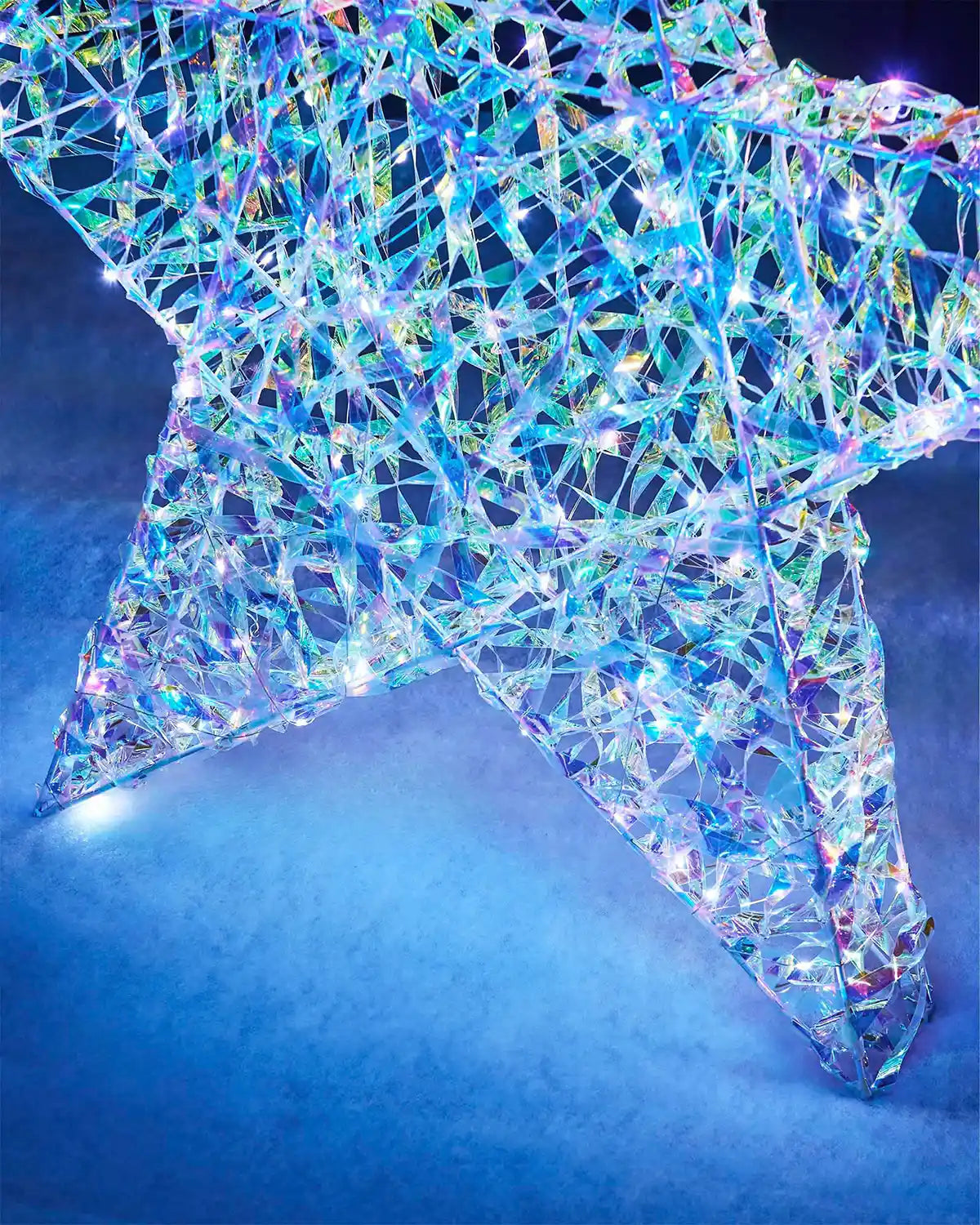 Detail close-up of the 81cm star silhouette with iridescent woven strips and bright white LEDs.