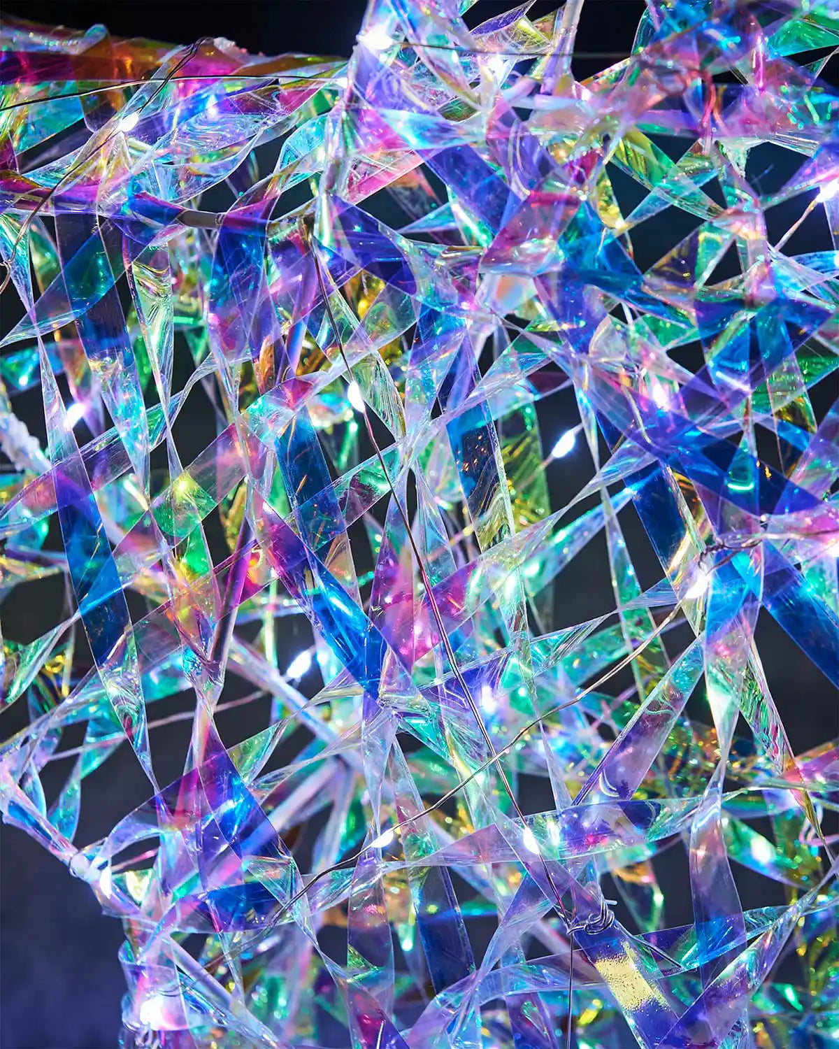 Close-up of the iridescent star texture with clear woven strips, wire frame and white lights.