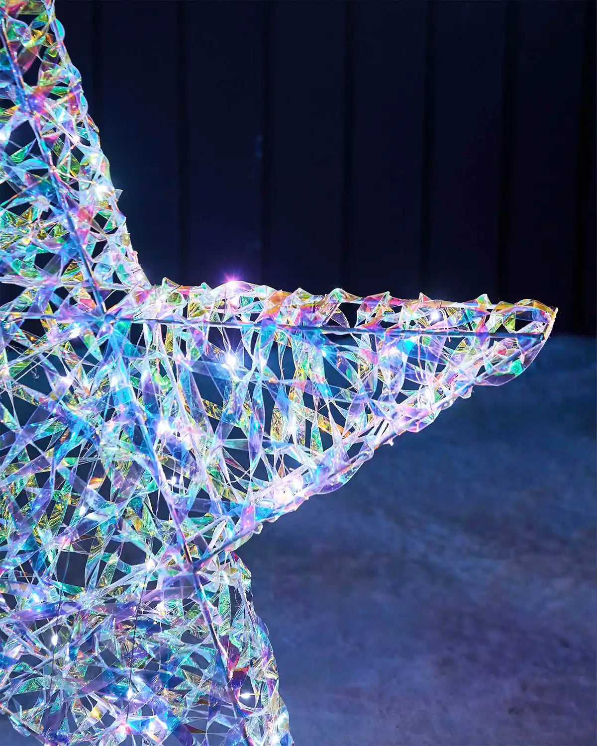 Close-up of the iridescent star point showing the woven frame and white LED lights.