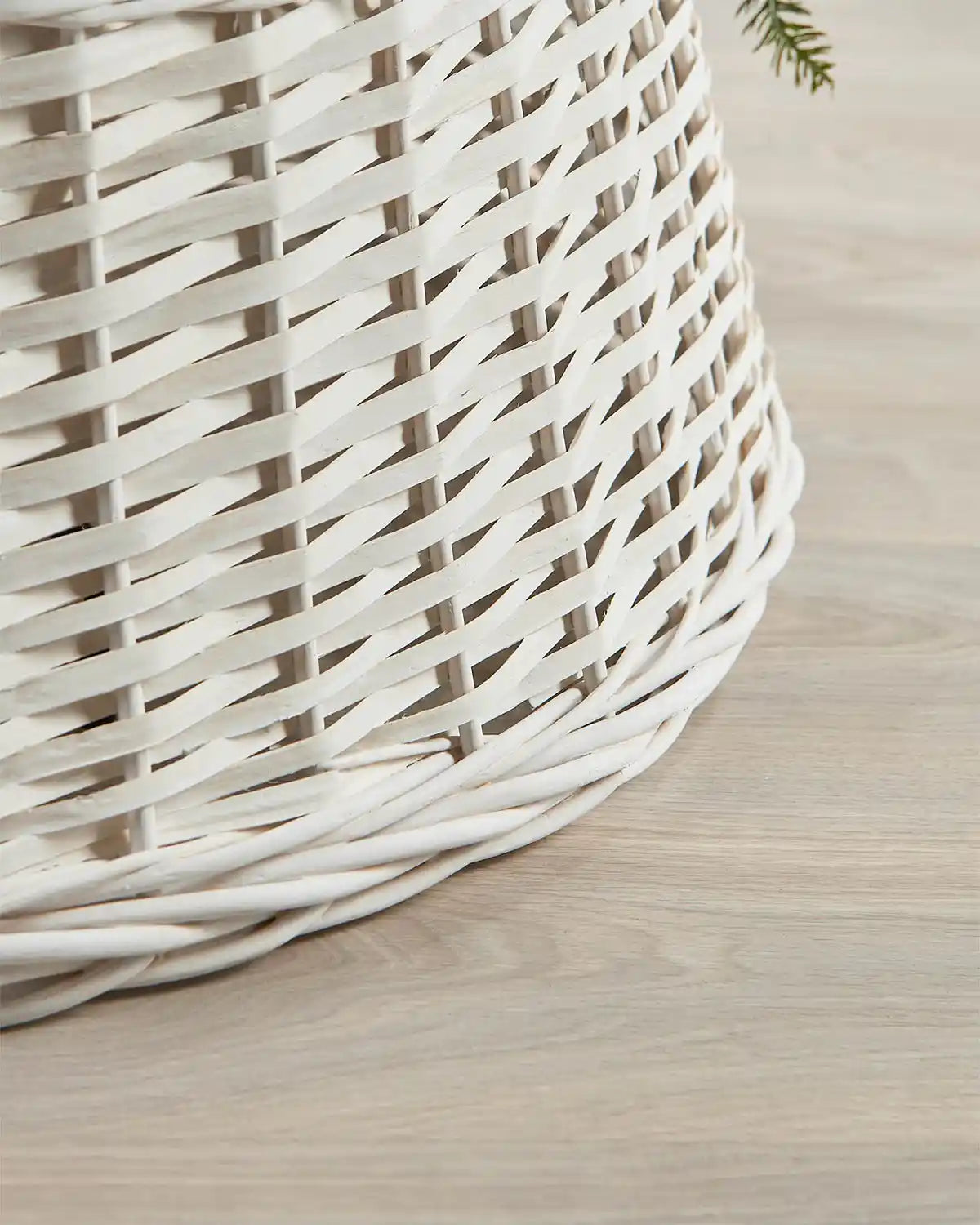 Detail view of the 85cm off-white wicker tree collar with a hand-woven rattan pattern and rounded lower edge.