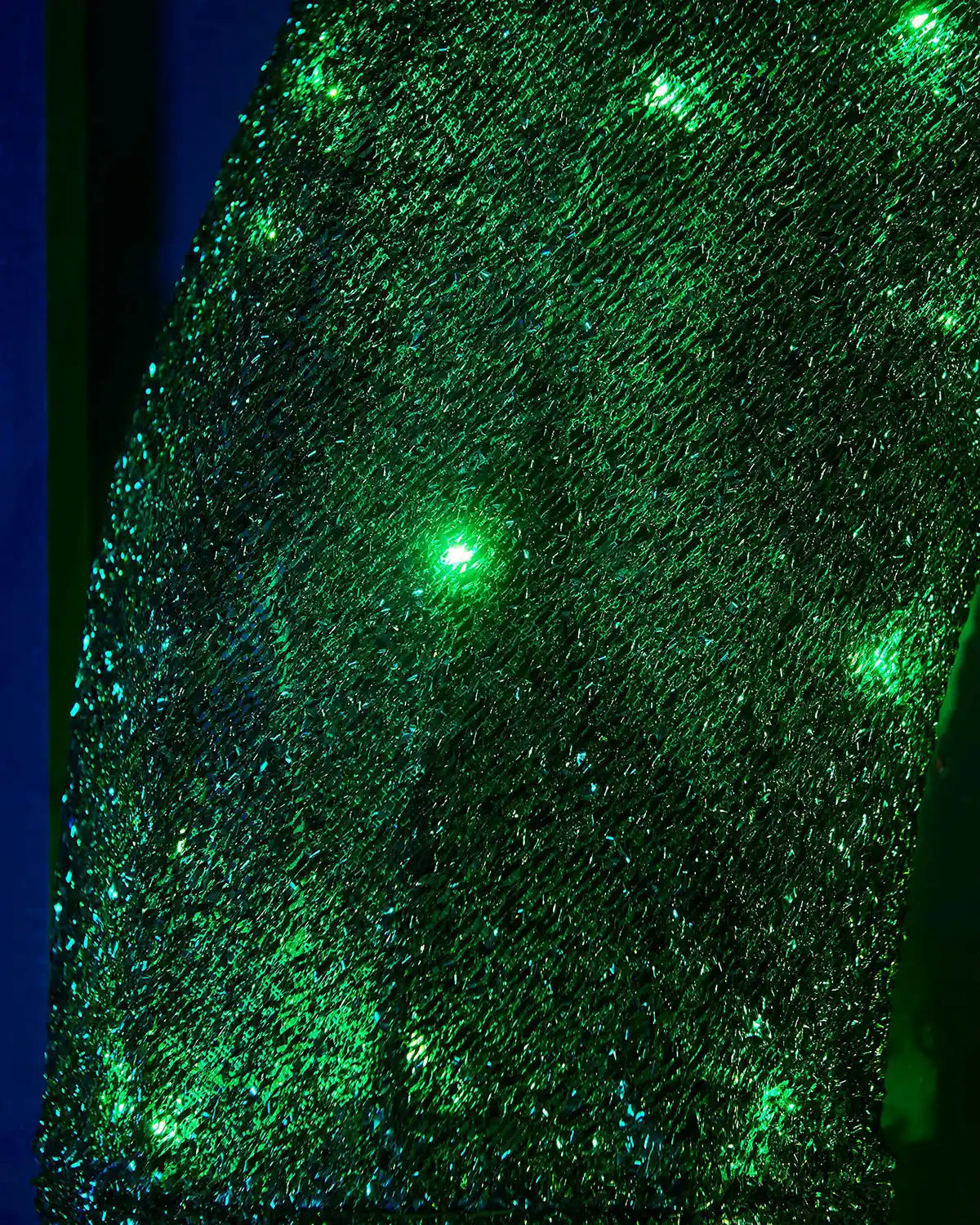 Close-up of the green wreath section with bright green LEDs and textured tinsel finish.