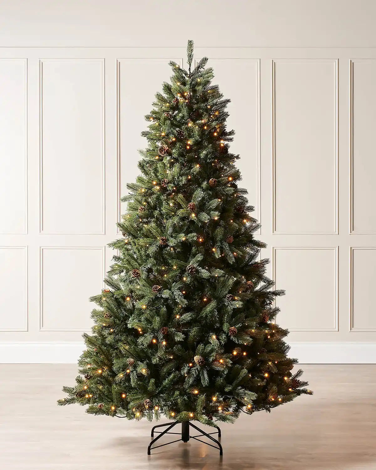 8 ft pre-lit Crawford pine Christmas tree displayed indoors with warm white lights and pinecones