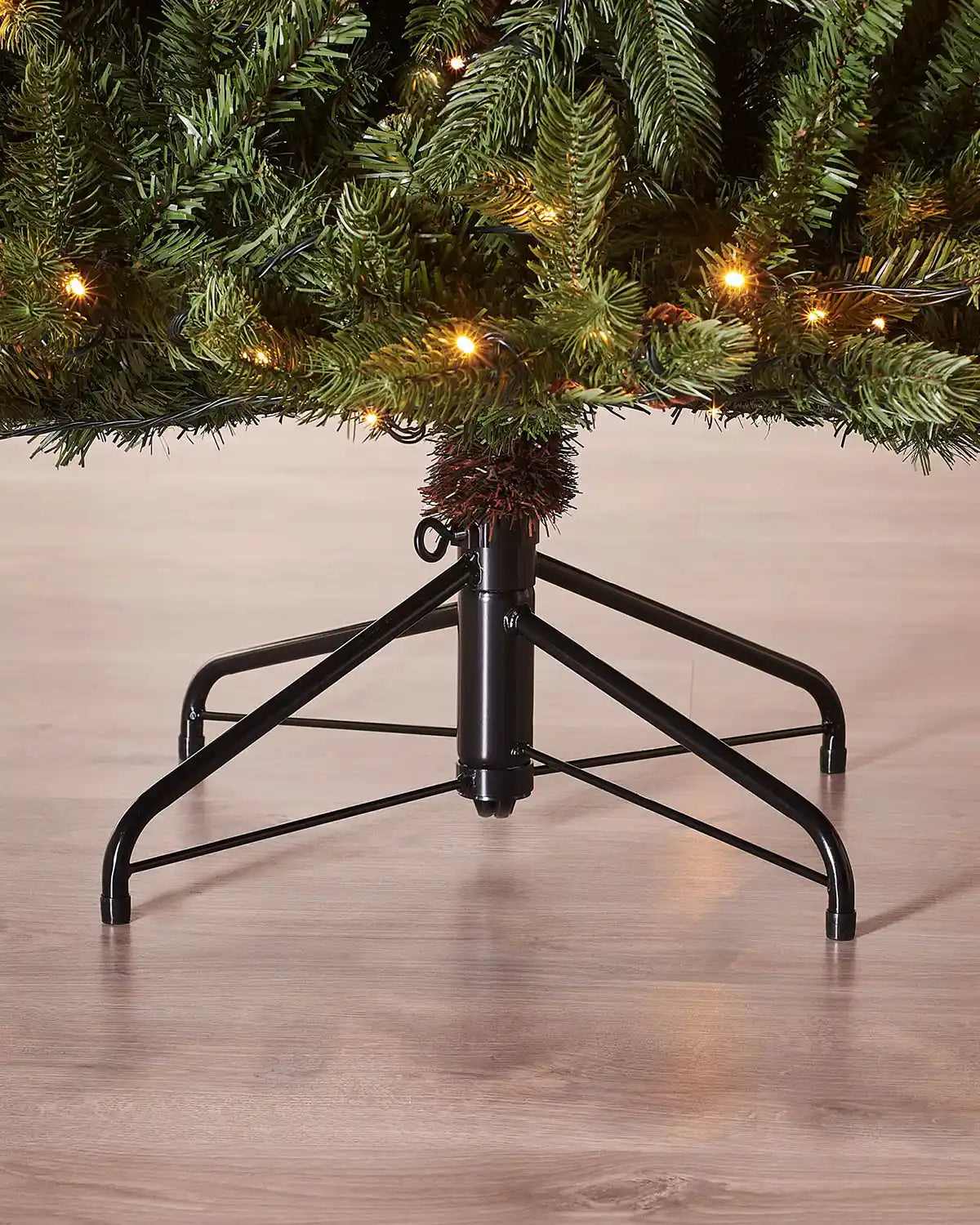 Close-up of the black metal stand supporting the pre-lit Crawford pine Christmas tree