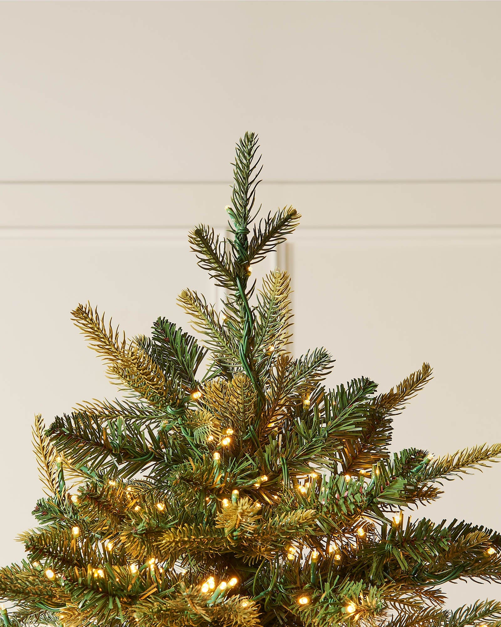 Top section of the 8ft pre-lit Highland fir Christmas tree with shaped branches and warm white lights.