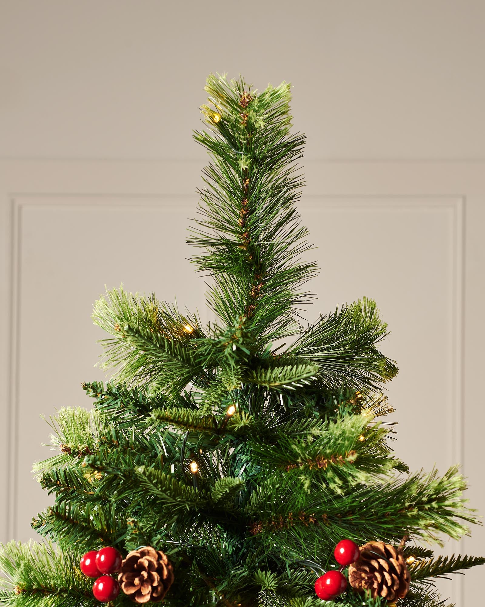 Top section of the 8ft pre-lit Victorian mixed tip Christmas tree with shaped branches, berries, pinecones and warm white lights.
