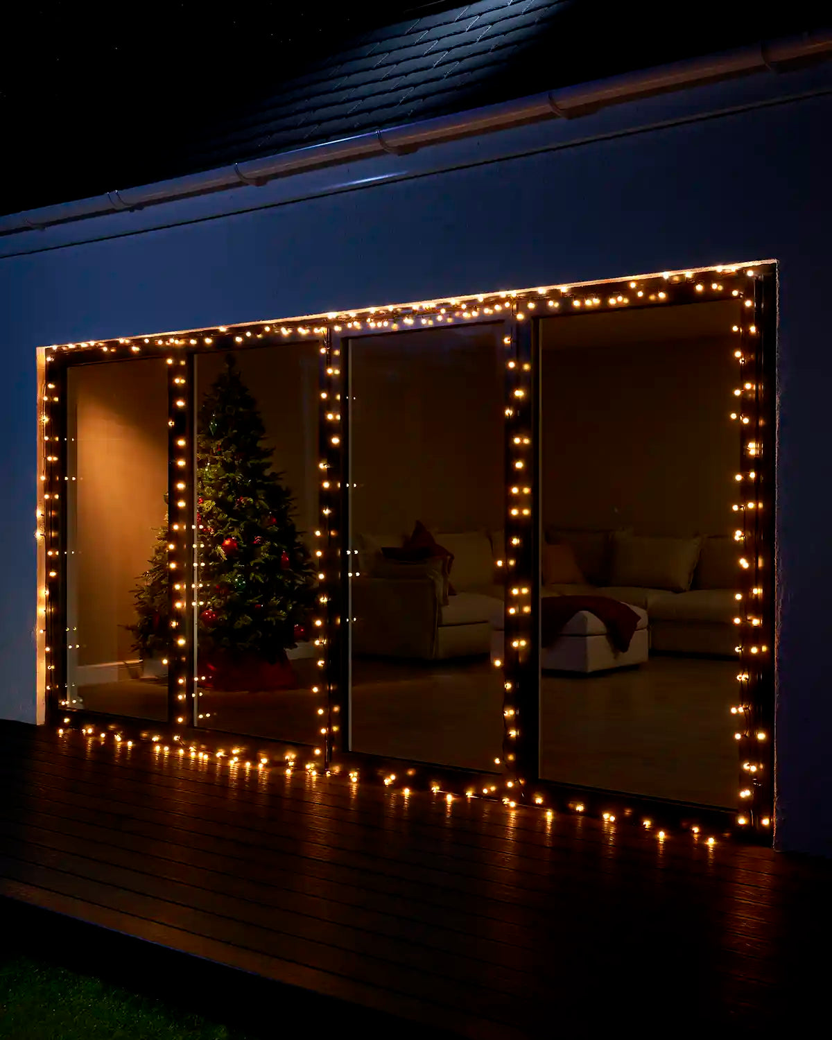 Warm white berry lights framing large patio doors at night.