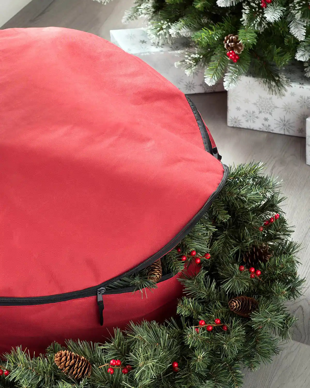 Red garland and wreath storage bag holding a Christmas garland indoors