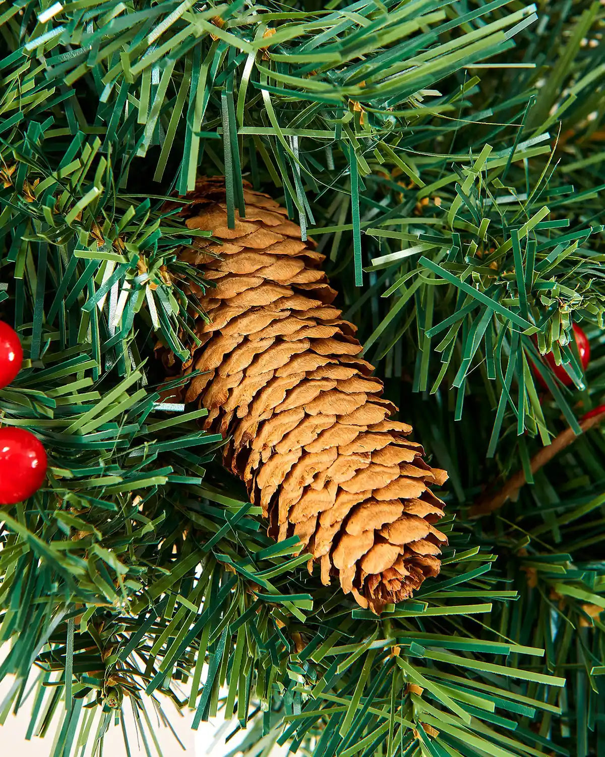 Close-up of a natural pine cone nestled in a green mixed pine Christmas garland