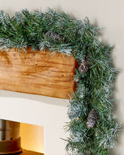 Close-up of a 9 ft frosted blue spruce garland with pinecones draped around a wooden mantelpiece
