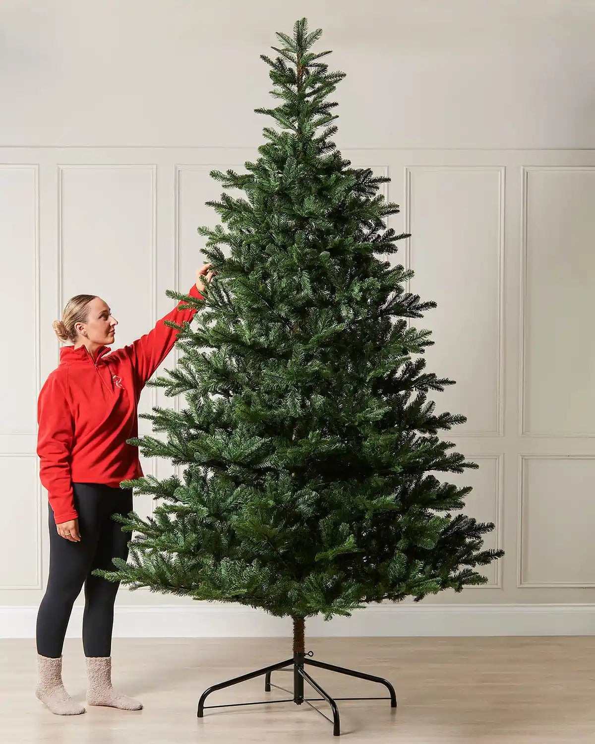 9ft Nordmann fir Christmas tree shown indoors beside a person for scale