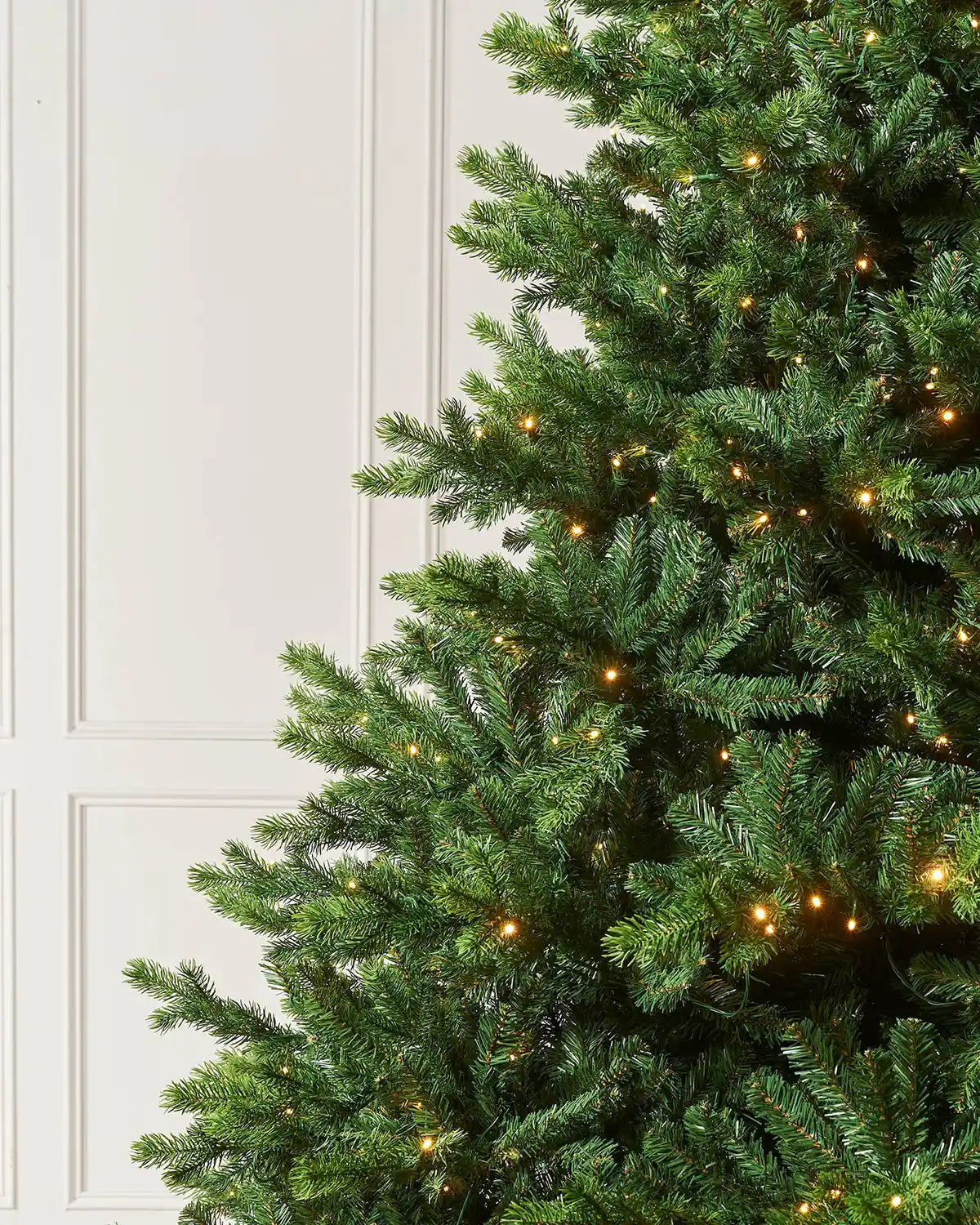 Close-up of the 9ft pre-lit balsam fir Christmas tree showing realistic green branches and warm white LED lights.