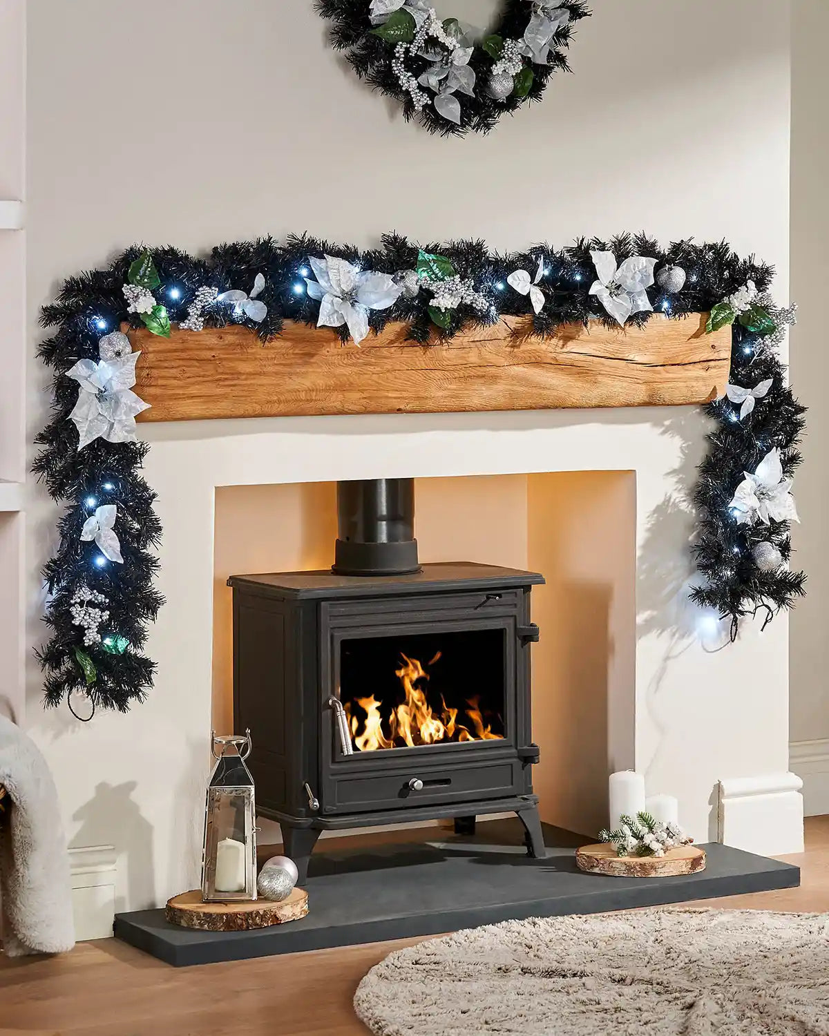 Pre-lit black and silver Christmas garland displayed around a mantelpiece with cool white LEDs and matching wreath