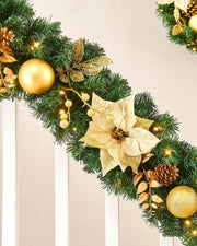 Close-up of cream and gold decorated Christmas garland with poinsettia, gold bauble and warm white LED lights