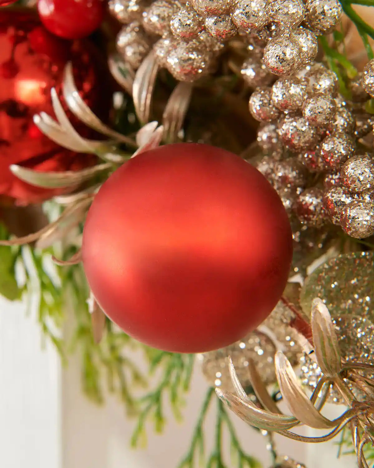 Close-up of glossy red berries, gold berries and warm white LED lights on the 9ft mixed tip garland.