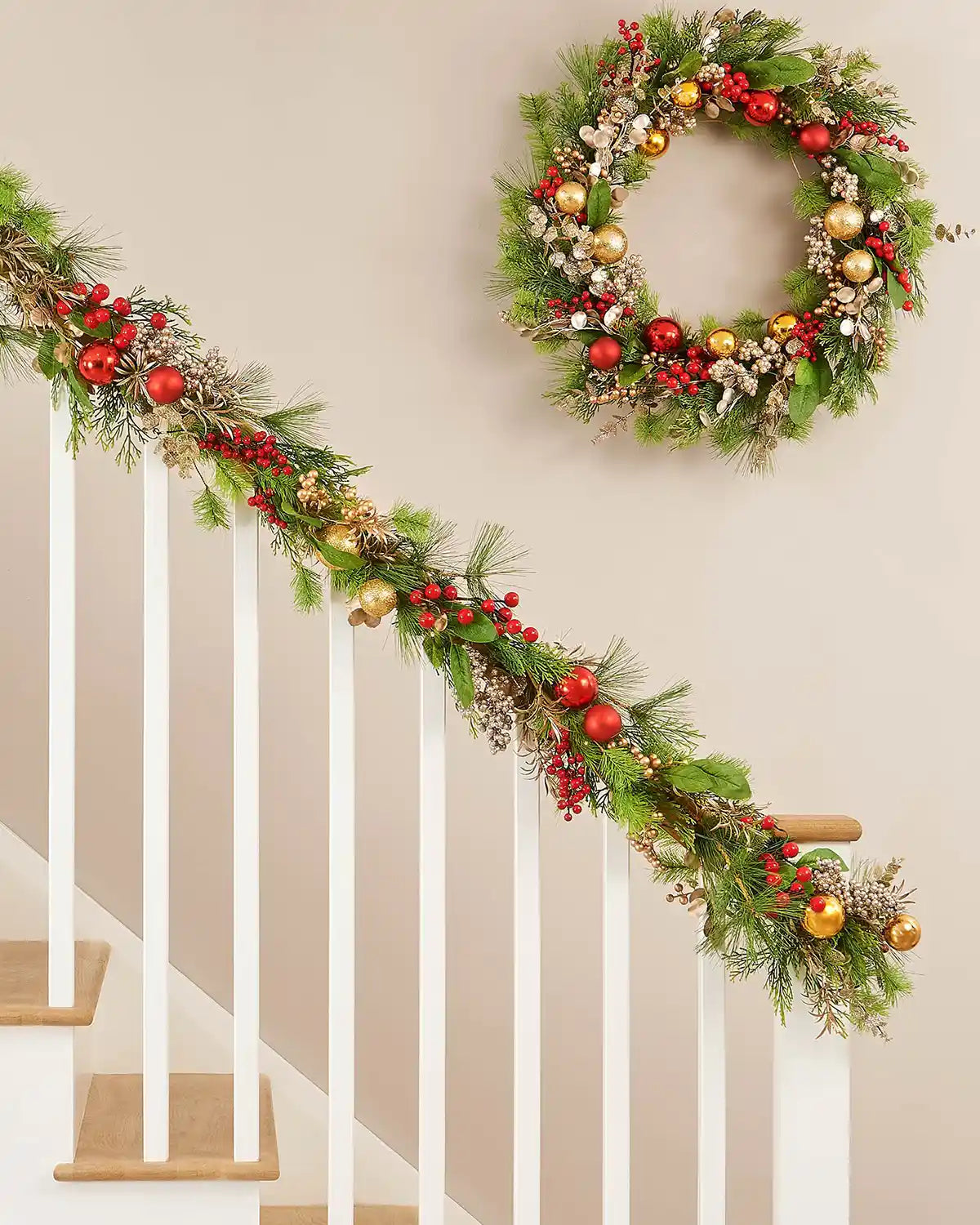 9ft pre-lit decorated mixed tip garland with red and gold details displayed along an indoor staircase.