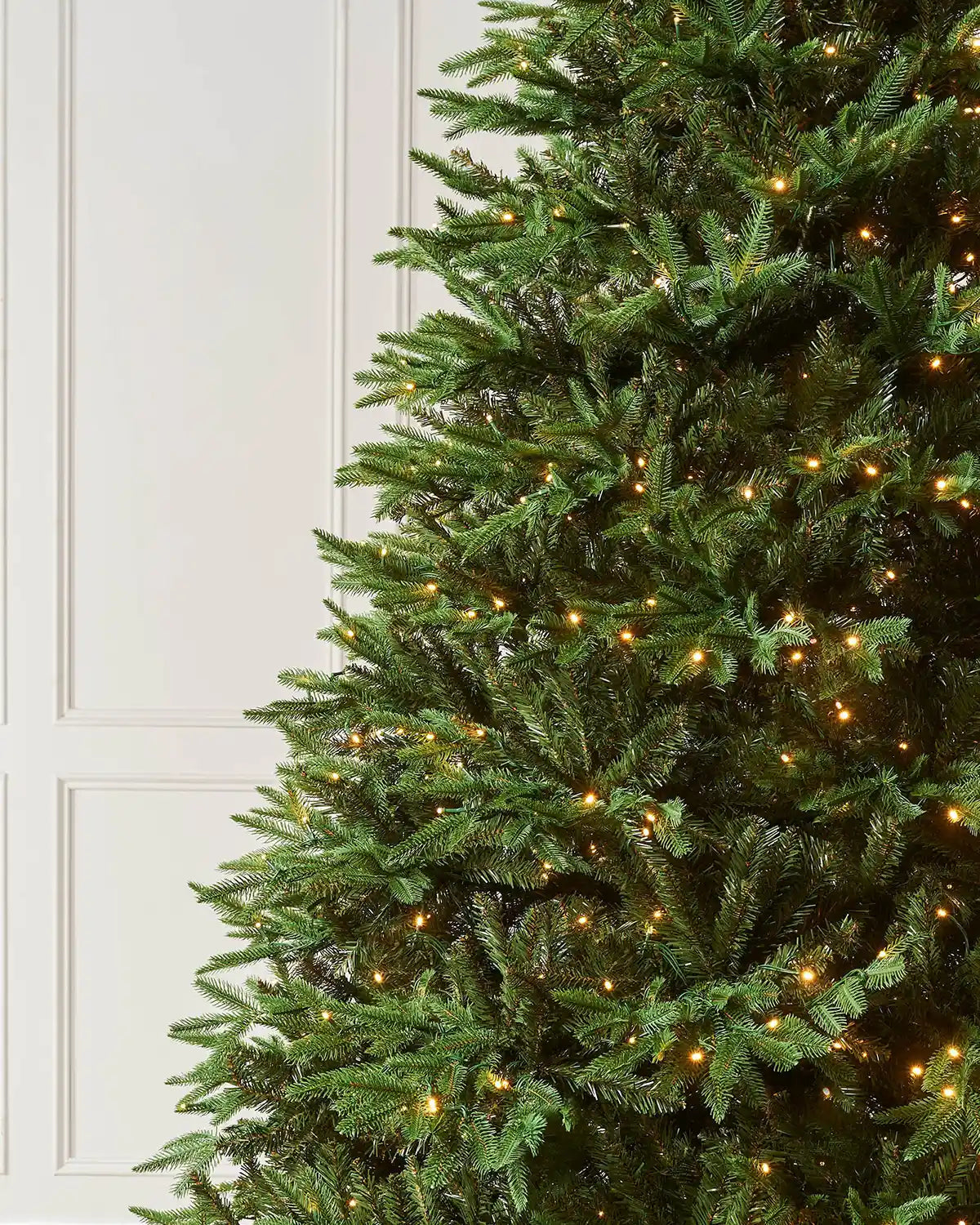Close-up of the 9ft pre-lit Royal Fir Christmas tree showing layered green branches with warm white LEDs.