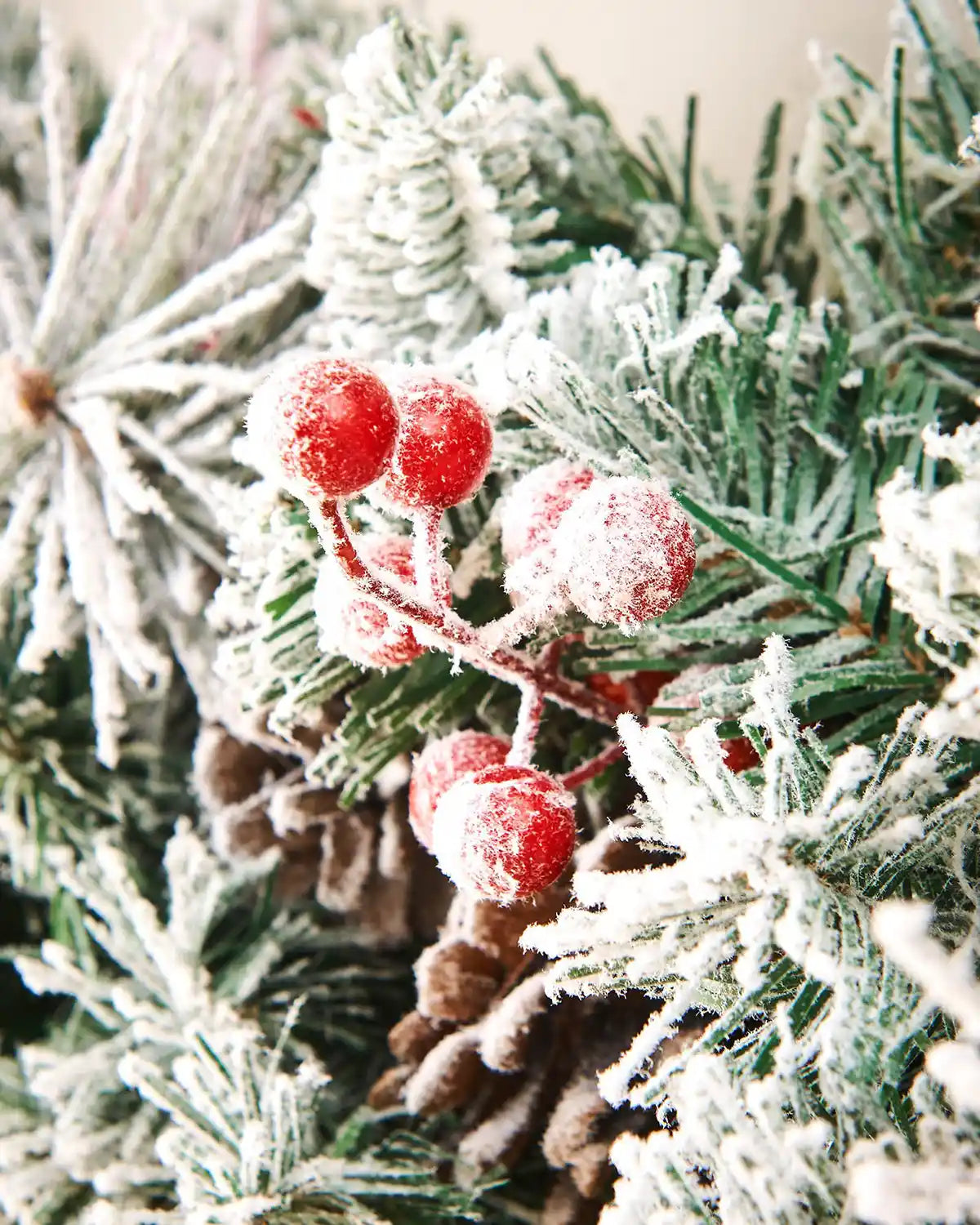 Close-up of red berries and frosted greenery on a snow flocked mixed pine garland