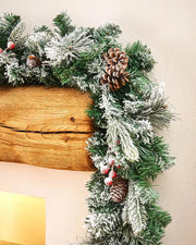 9ft extra thick mixed pine snow flocked garland displayed around a wooden mantelpiece