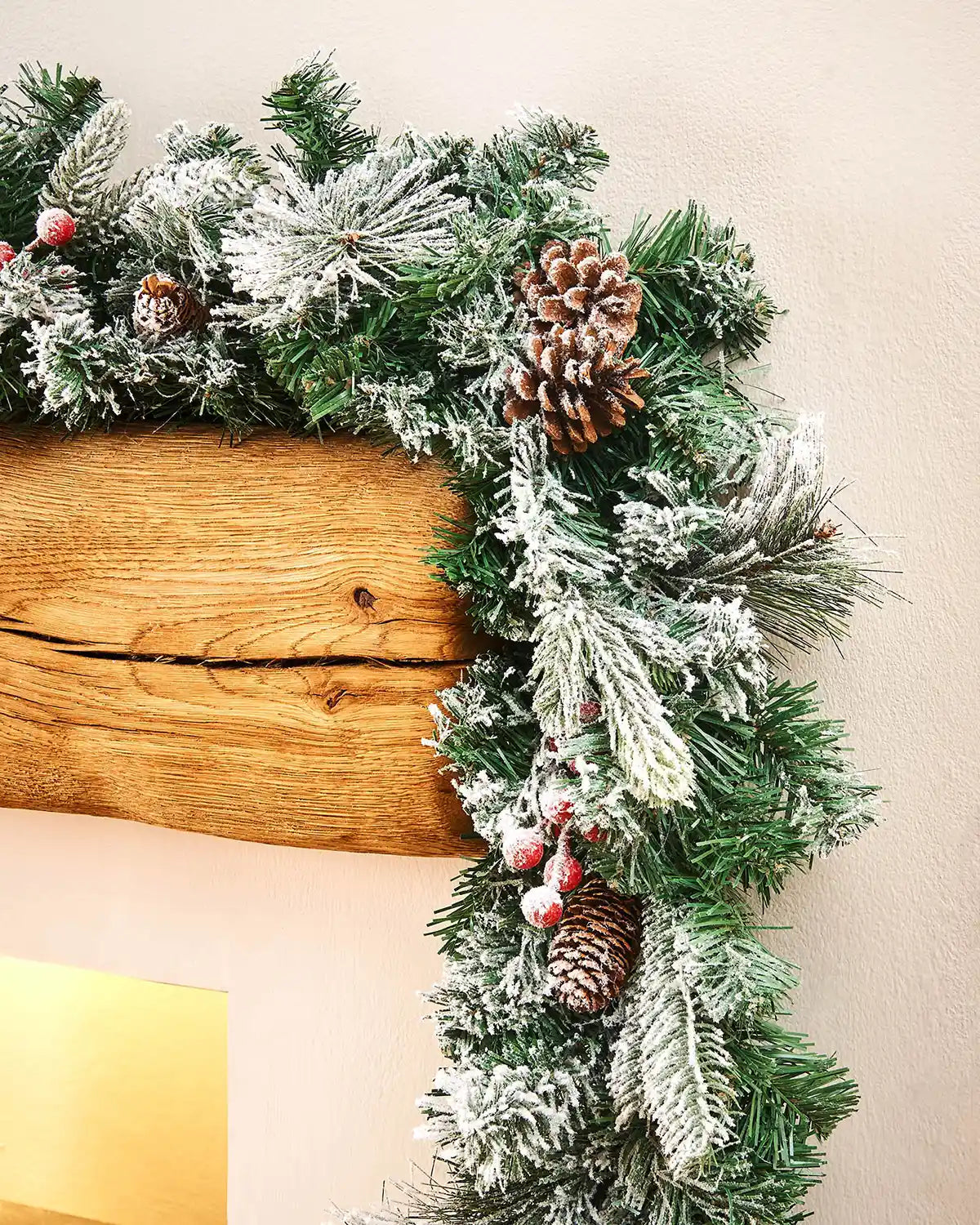 9ft extra thick mixed pine snow flocked garland displayed around a wooden mantelpiece