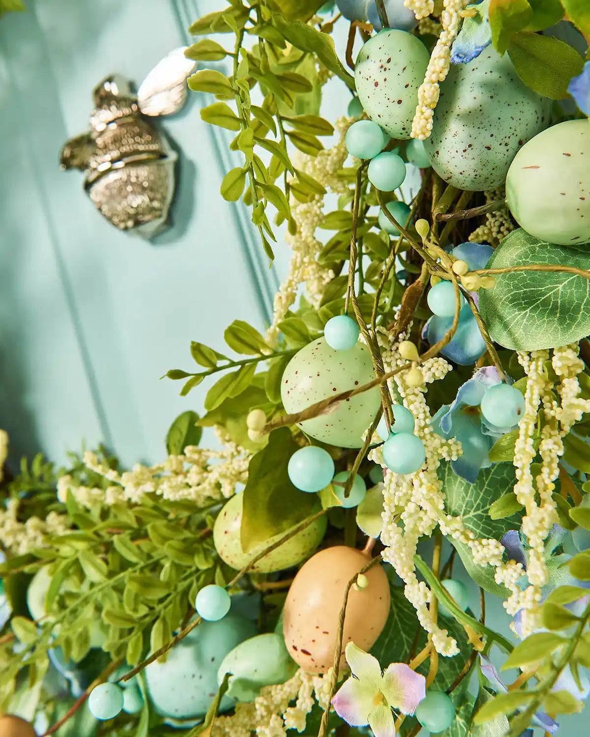 A Blue, 28 inch, Artificial Floral Egg Spring Wreath, low, right angle shot.