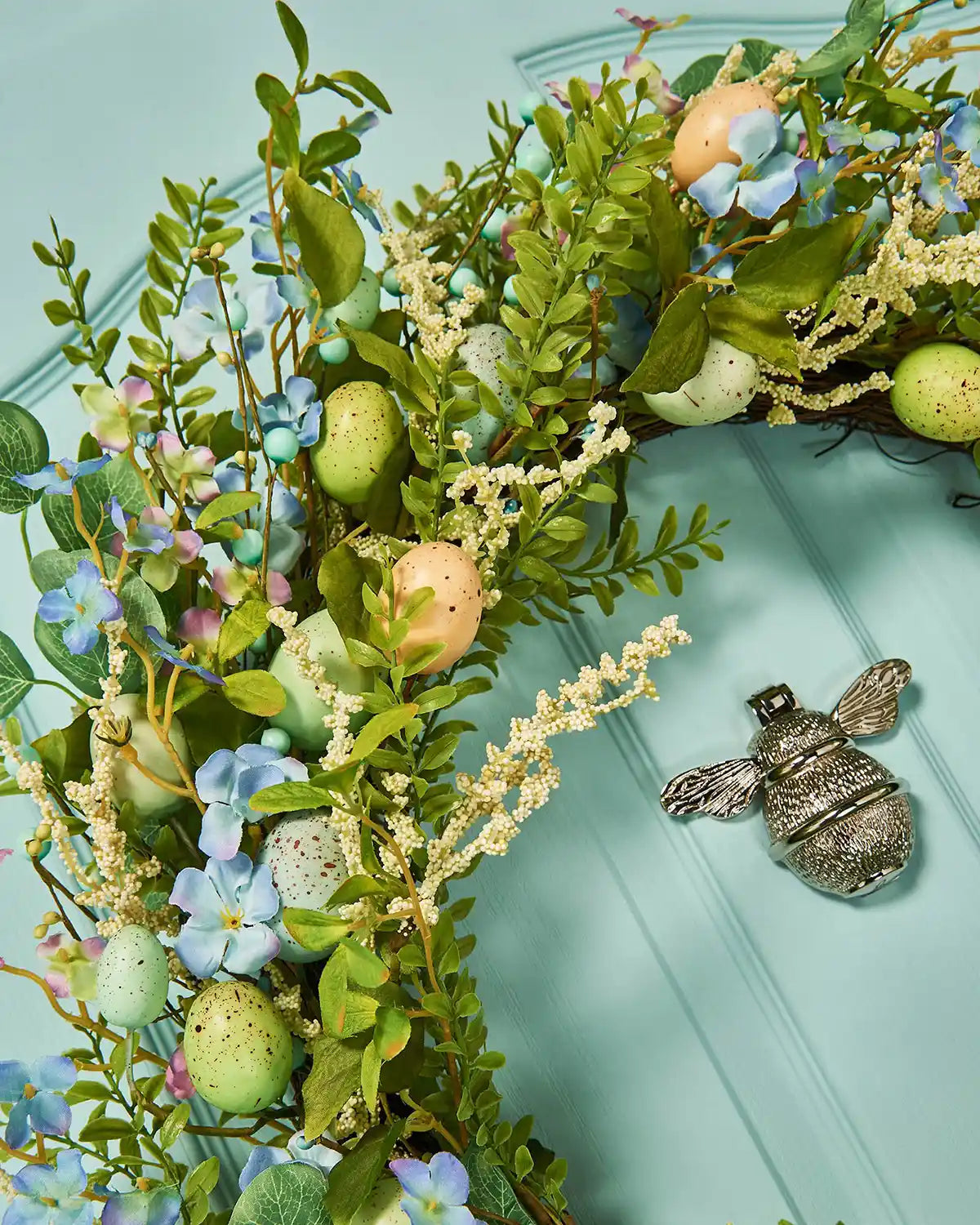 A Blue, 28 inch, Artificial Floral Egg Spring Wreath, top left, angle shot.