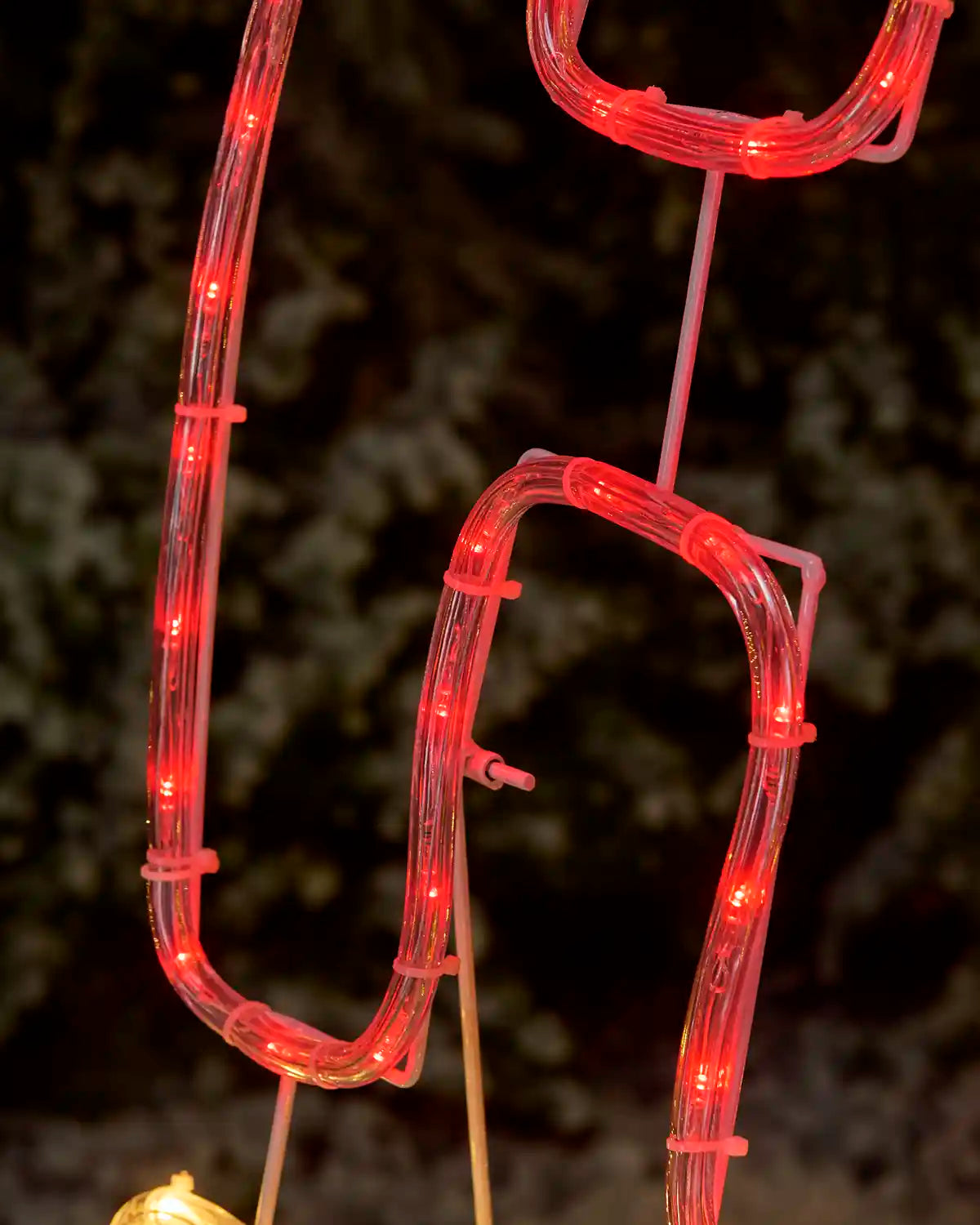 A close-up of a red illuminated decorative rope light that forms the word 'ho' from ho ho ho 