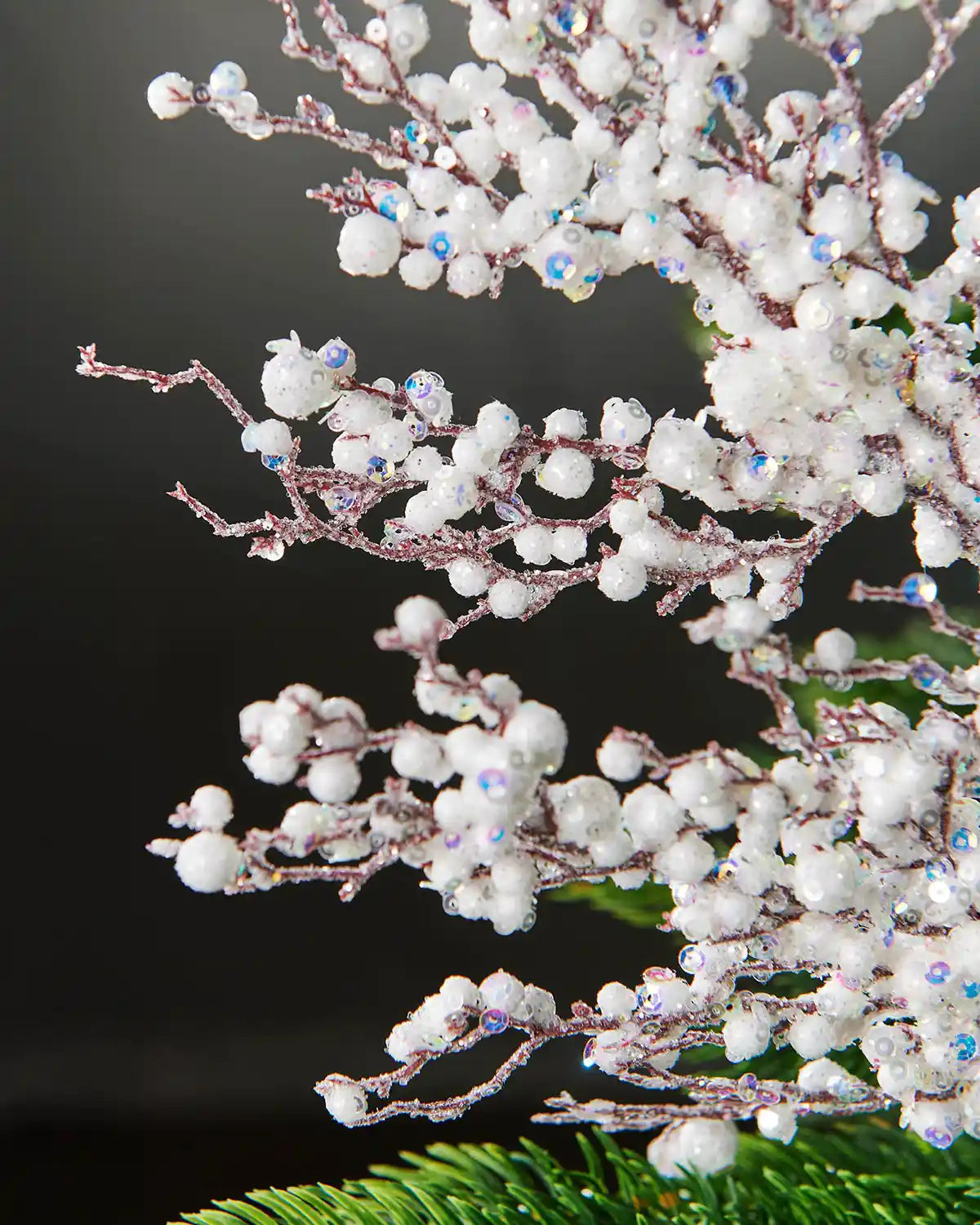 Additional close-up of white pearls crystal in front of grey wall background highlighting iridescent sequins