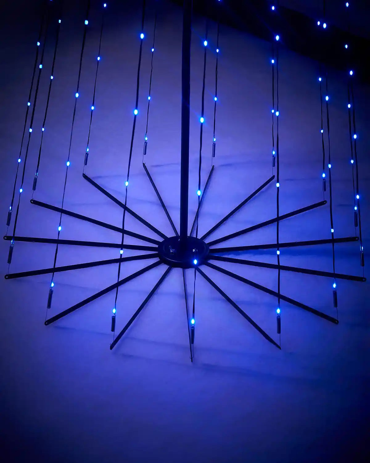 Base of decorative light fixture with blue LED lights on a dark background